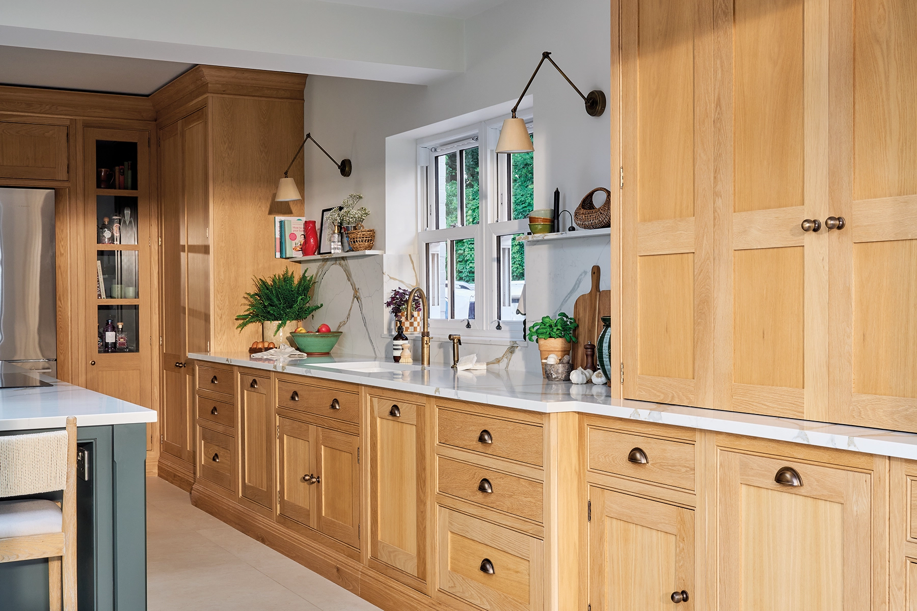 Bespoke oak family kitchen with deep green island, brass handles and traditional detailing