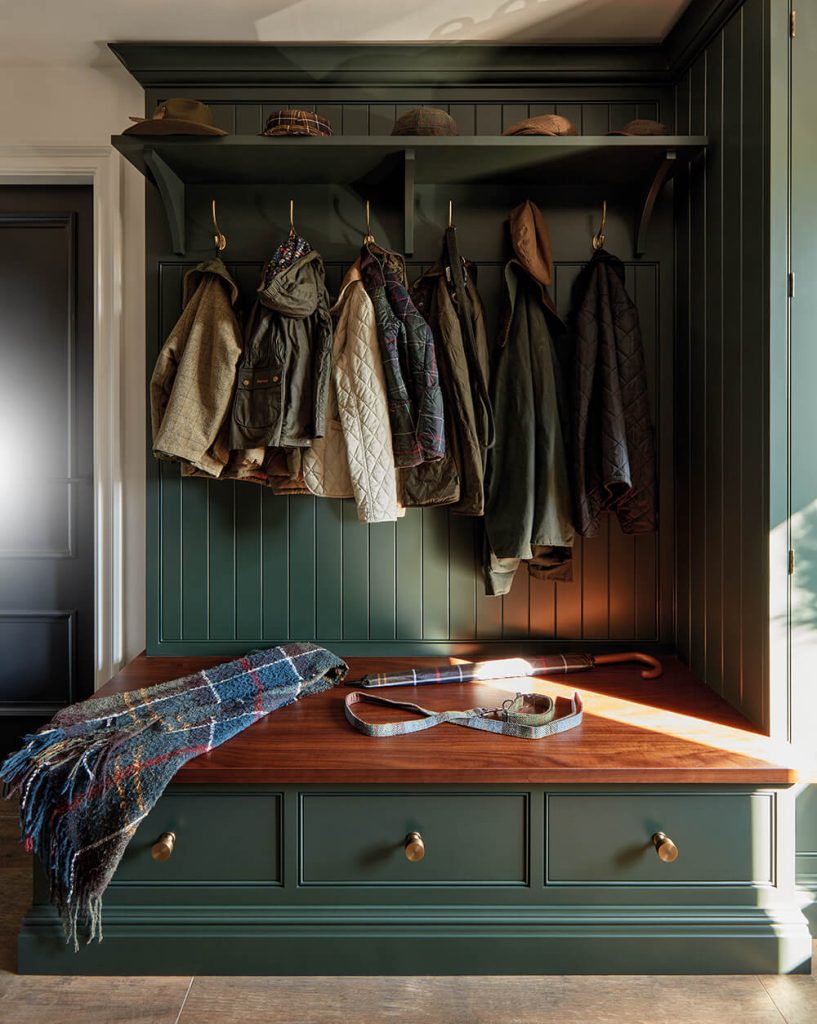 Green boot room bespoke bench seating with hooks and drawer storage.