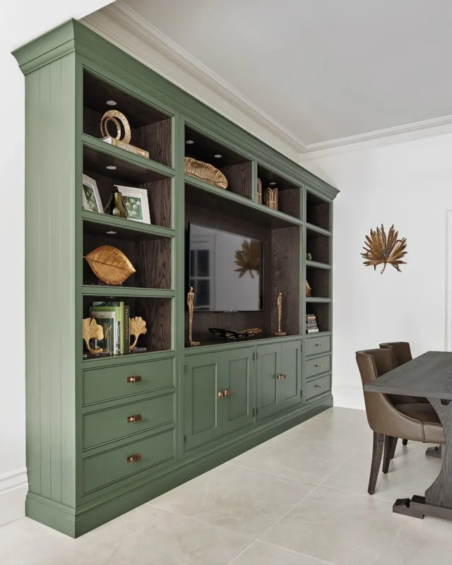 This deep green TV nook creates a defined space within the kitchen for unwinding in style. Open shelving neatly frames the widescreen TV, keeping the area clean and clutter-free while providing just enough room for essentials. Soft lighting from the glazed cabinets then adds a gentle, ambient glow, perfect for creating a cosy atmosphere without distraction.

Collection: Hartford
Colour: Green Meadow

-

#tomhowley #bespokecabinetry #greeninteriorideas #interiordesign #kitchenzoning #mediaunit #mediawall #luxurykitchen