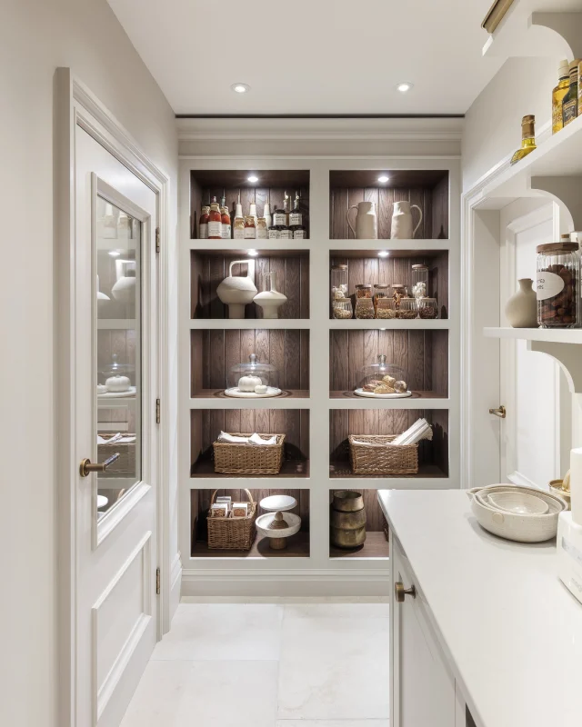 A well-ordered pantry is a quiet luxury. This walk-in example, painted in Anise with Tudor Oak accents and burnished brass handles, brings together storage and refinement. Open shelving, neatly stacked drawers, and wicker baskets make everything easy to find, while Calacatta Gold worktops provide a durable surface that feels tactile under the hand.

Book your complementary design visit to see how our designers can turn your storage dreams into reality - link in bio.